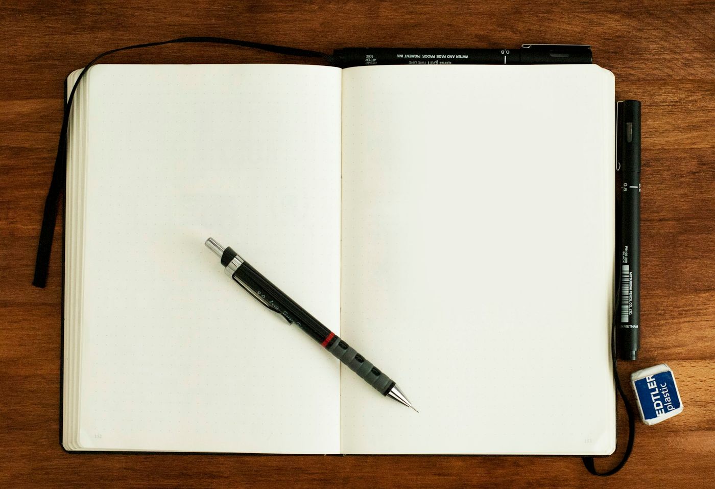 Caneta sobre um caderno aberto em branco.