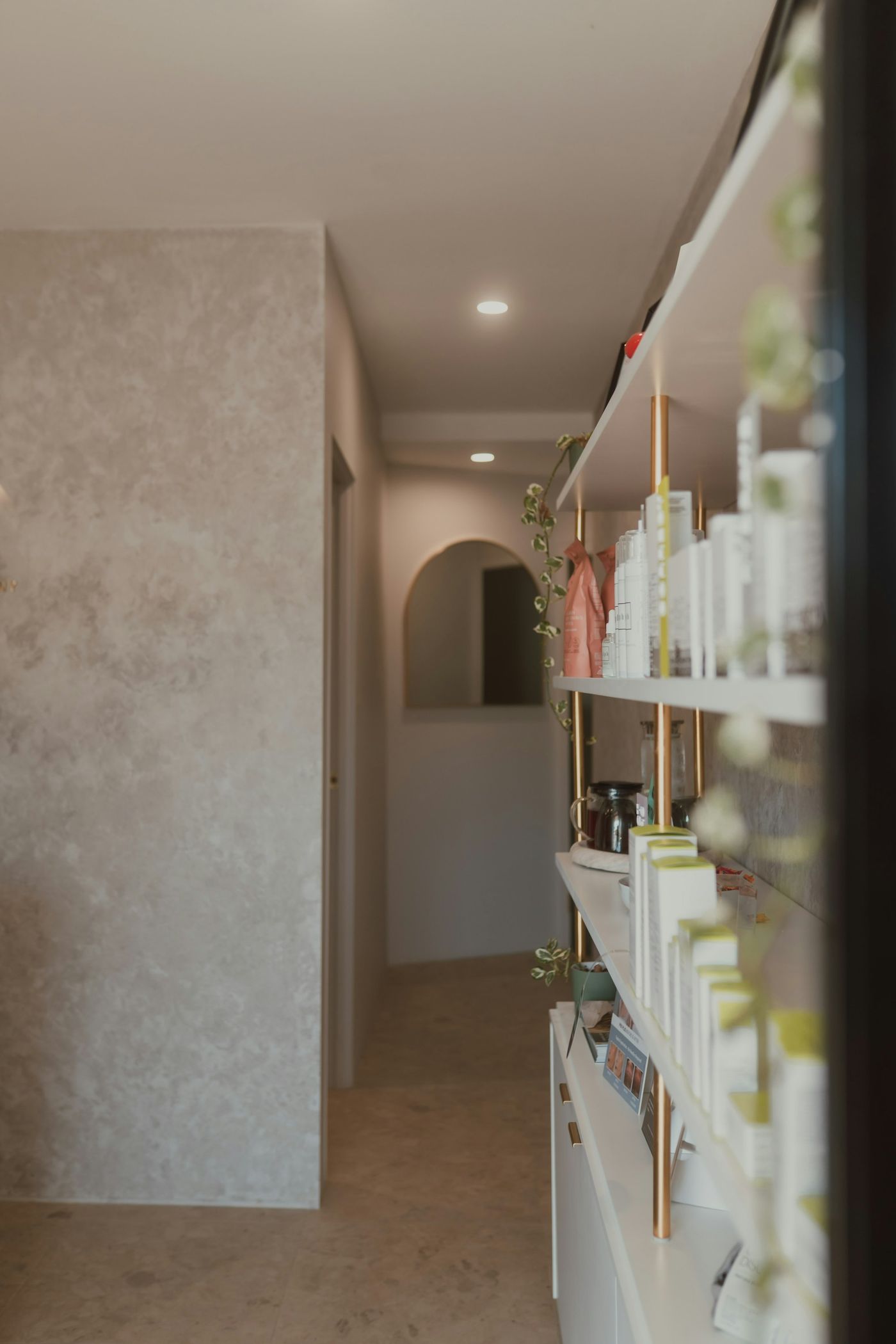 Prateleiras com produtos de cuidado com a pele num corredor iluminado.